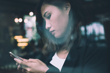 Young woman reading news on mobile phone during rest in coffee shop.