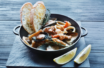 Seafood Stew in Saucepan on dark wood background