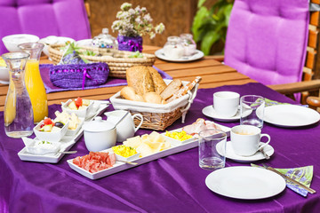 Fresh Breakfast or brunch with ham, eggs, bread, yogurt, fruits and coffee