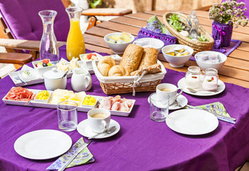Fresh Breakfast or brunch with ham, eggs, bread, yogurt, fruits and coffee