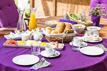 Fresh Breakfast or brunch with ham, eggs, bread, yogurt, fruits and coffee