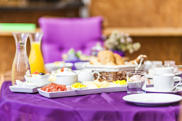 Fresh Breakfast or brunch with ham, eggs, bread, yogurt, fruits and coffee