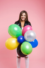 Woman in leather jacket posing with bunch of colored balloons