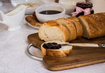 Sliced loaf of bread with currant jam with jar