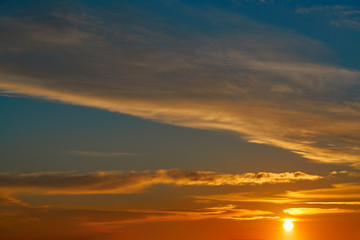 Sunset sky orange clouds over blue