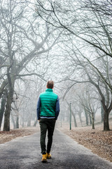 man walking through a fog forest