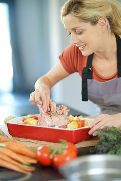 Woman in kitchen cooking dish for dinner