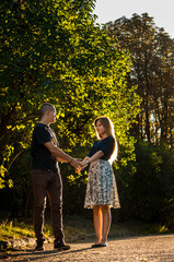 Happy young couple affectionately holding hands and looking at each other in love