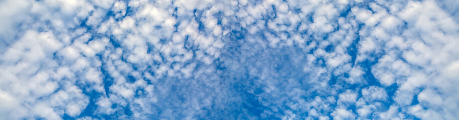 Bizarre shapes of flying clouds in the blue sky. Heavenly background in a highly patterned top. Free space atmospheric flight and freedom.