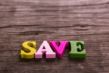 save word made from colored wooden letters on an old table. Concept