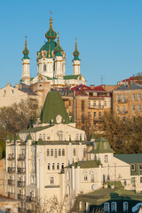 Fototapeta na wymiar Famous St Andrew church and descent with artistic fare in Podol, historic district of Kiev 