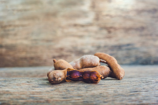 Sweet ripe tamarind pods on old wood background