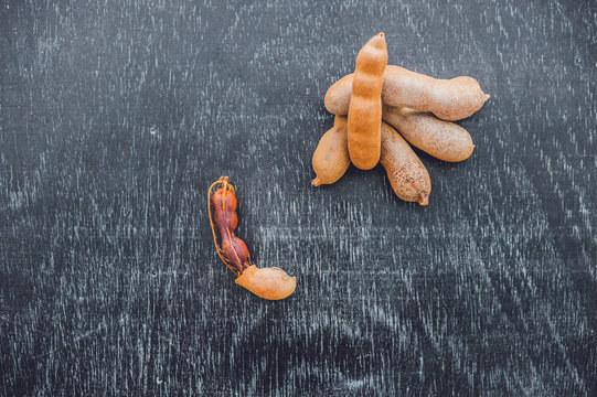 Sweet ripe tamarind pods on old wood background