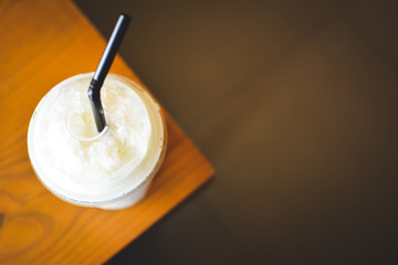 Ice coffee on a wooden table in coffee shop background hipster tone soft and selective focus 