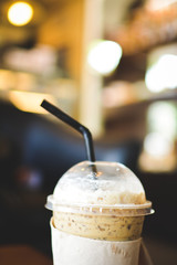Ice coffee on a wooden table in coffee shop background hipster tone soft and selective focus 