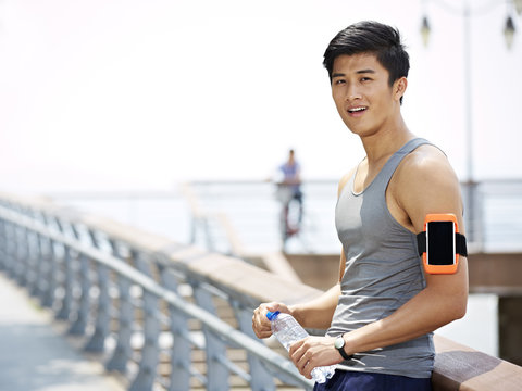 Young Asian Man Taking A Break During Outdoor Exercise