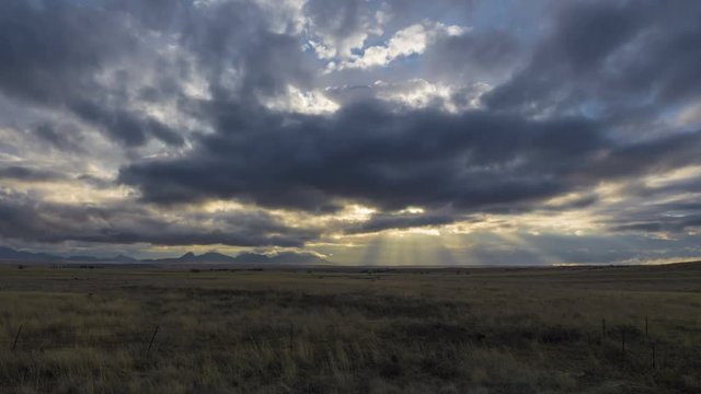 Time lapse of sunbeams and clouds over a ranch land prairie