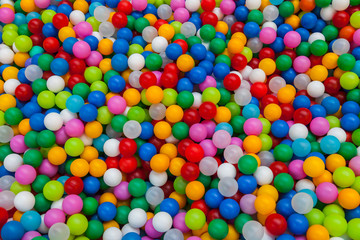 Fototapeta na wymiar Colored plastic toy balls of different color for the children's pool dry. View from afar. Picture background, wallpaper, texture, pattern.