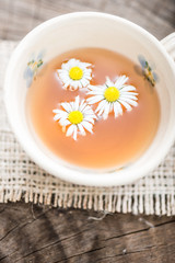 chamomile tea in a glass cup on wooden background