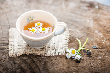 chamomile tea in a glass cup on wooden background