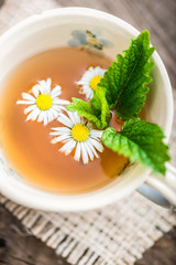 chamomile tea in a glass cup on wooden background