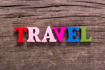 travel word made from colored wooden letters on an old table. Concept