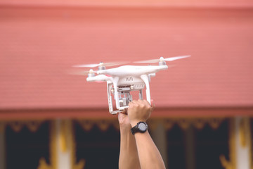 Man holding drone with hand outdoor.