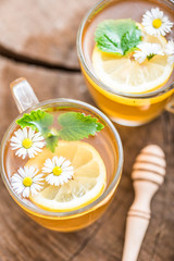 chamomile tea in a glass cup on wooden background