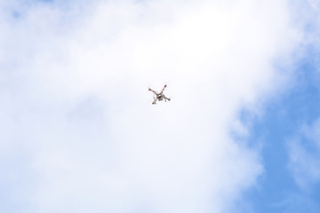 White drone, quadrocopter with photo camera flying concept on the sky.