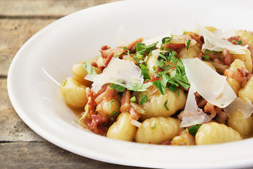 Gnocchi with parmesan and herbs on white plate