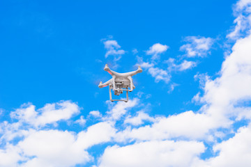 White drone, quadrocopter with photo camera flying concept on the sky.