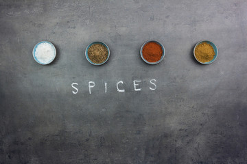 Top view on salt and spices on grey kitchen counter.