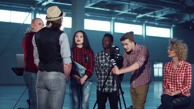 Person teaching people about film making process. Camera moving around. Stabilized shot