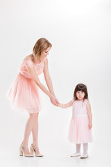 Fototapeta na wymiar blonde mom holding the hand of sweet little daughter in pink dre