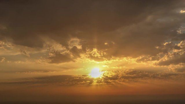 time lapse of clouds crossing the amazing sky over the sea or ocean at sunset. transition from day to night. The clouds cross slowly from left to right colored yellow orange purple blue