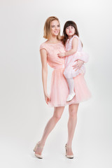 mom blonde holding cute little daughter in pink Princess dress o