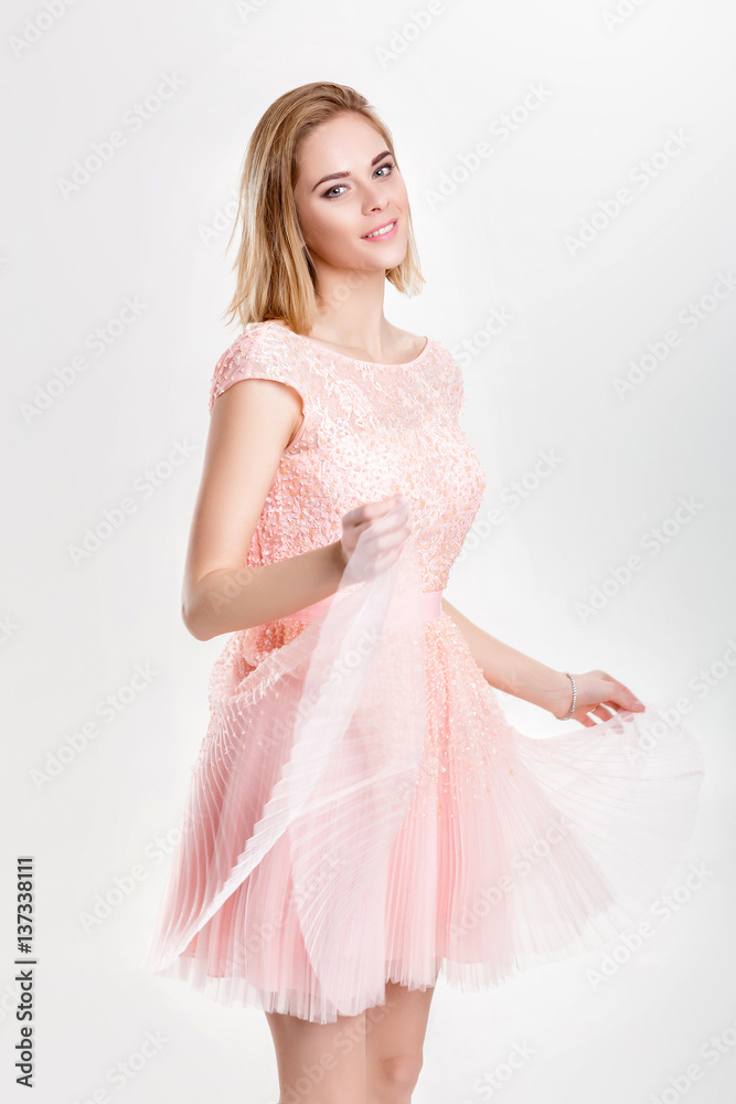 Wall mural beautiful blond woman in a pink cocktail dress dancing and havin