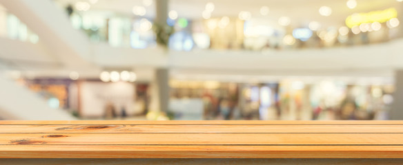 Wooden board empty table blurred background. Perspective brown wood table over blur in department store background, Panoramic banner - can be used mock up for montage products display or design.