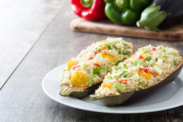 Stuffed eggplant with quinoa and vegetables on wooden background
