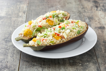 Stuffed eggplant with quinoa and vegetables on wooden background
