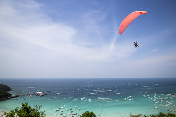 Paraglider flying over mountains in Larn Island Thailand