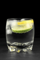 Mineral water in the glass with lime and lemon slices
