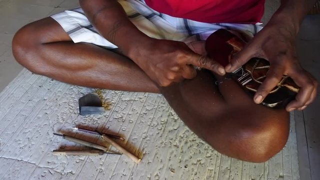 Indigenous Fijian man wood carving a sea turtle