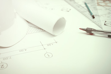 Civil engineer tools during worked at home office with white safety helmet ,divider,ruler and blue print..