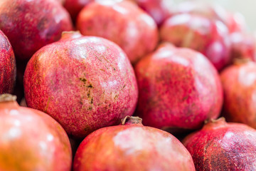 Macro closeup of many pomegranates on display