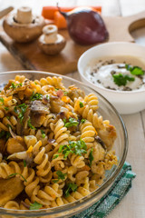 Integral pasta with chicken, mushrooms, vegetables, spices and Greek yogurt. White wooden background.