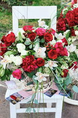 Fototapeta na wymiar Big bouquet of pink and red roses on a white chair, beautiful wedding bouquet