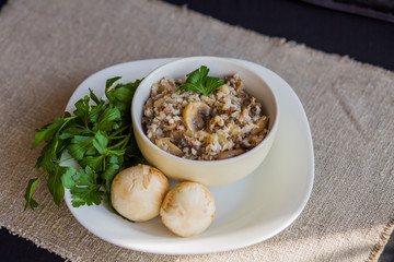Buckwheat porridge with stewed mushrooms and onions in a plate on the table