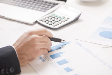 Hands of financial manager taking notes when working