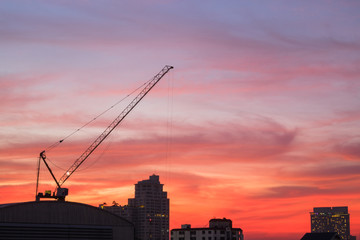 Silhouette of industrial construction crane at sunrise